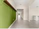 Bright hallway featuring sleek tile flooring, neutral walls, and decorative green wood paneling with rustic wooden shelf at 9209 Sw 58Th Cir, Ocala, FL 34476