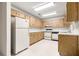 Functional kitchen with white appliances, light wood cabinetry, and tile flooring at 9367 Sw 83Rd Ave # C, Ocala, FL 34481