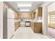 Functional kitchen with white appliances, light wood cabinetry, and tile flooring at 9367 Sw 83Rd Ave # C, Ocala, FL 34481