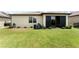 Backyard with lush green grass and a covered patio with sliding glass doors at 9634 Sw 67Th St, Ocala, FL 34481