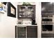 A butlers pantry featuring a wine cooler, ovens, upper glass front cabinets, and a beverage station at 9634 Sw 67Th St, Ocala, FL 34481