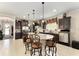 A large kitchen island offers seating with dark cabinets, tile flooring and granite countertops at 9634 Sw 67Th St, Ocala, FL 34481