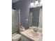 This bathroom vanity features ample counter space, lighting, and a shower reflected in mirror at 9711 Sw 97Th Pl, Ocala, FL 34481