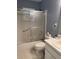 This bathroom boasts a tub and shower combination with a sliding glass door enclosure at 9711 Sw 97Th Pl, Ocala, FL 34481