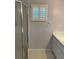 Bathroom featuring tile floors, framed window with shutters, shower stall and updated vanity at 9711 Sw 97Th Pl, Ocala, FL 34481