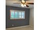 This bedroom features a ceiling fan and a window with white shutters, providing natural light at 9711 Sw 97Th Pl, Ocala, FL 34481