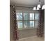 Bright dining area with shuttered windows, patterned curtains, and a modern chandelier at 9711 Sw 97Th Pl, Ocala, FL 34481