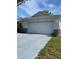 Two-car garage with white door and concrete driveway of a single story home at 9711 Sw 97Th Pl, Ocala, FL 34481