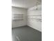 Spacious garage interior featuring built-in wall shelves and lighting at 9711 Sw 97Th Pl, Ocala, FL 34481