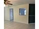 Open living room has tiled floor and a pass-through window to the kitchen at 9711 Sw 97Th Pl, Ocala, FL 34481