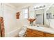 Bright bathroom featuring a shower and tub combination, a sink with vanity, and a large mirror at 13100 Se 93Rd Terrace Rd, Summerfield, FL 34491