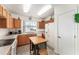 Efficient kitchen featuring oak cabinets, white appliances, an island, and a window above the sink for natural light at 13100 Se 93Rd Terrace Rd, Summerfield, FL 34491