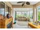 Relaxing sunroom filled with natural light, comfortable seating, and cozy fireplace feature at 13100 Se 93Rd Terrace Rd, Summerfield, FL 34491