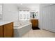 Bright bathroom with a corner tub, white tile surround, and wood cabinets at 15776 Sw 11Th Terrace Rd, Ocala, FL 34473