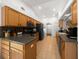 Bright kitchen with tan tile floors, wood cabinets, black appliances, and tile backsplash at 15776 Sw 11Th Terrace Rd, Ocala, FL 34473