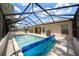 Enclosed screened pool features clear blue water and a covered roller for protection at 15776 Sw 11Th Terrace Rd, Ocala, FL 34473