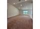 Bright, open living space with vaulted ceilings, carpet, and large windows for natural light at 180 Willow Rd, Ocala, FL 34472