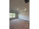 Large bedroom with carpet flooring, tray ceiling, and a bright window at 180 Willow Rd, Ocala, FL 34472