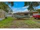 Expansive backyard with covered boat, tent, mature trees, and lawn, ideal for outdoor activities at 2508 India Palm Dr, Edgewater, FL 32141
