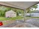 Spacious backyard featuring a large storage tent, a boat, and well-maintained lawn at 2508 India Palm Dr, Edgewater, FL 32141
