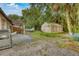 Large backyard with a tent for storage, boat, grill, and a mix of grass and gravel at 2508 India Palm Dr, Edgewater, FL 32141