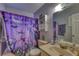 Functional bathroom with decorative shower curtain, single sink vanity, and storage cabinet at 2508 India Palm Dr, Edgewater, FL 32141