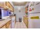 Compact kitchen with white appliances, tile flooring and wood cabinets, offering practical functionality at 2508 India Palm Dr, Edgewater, FL 32141