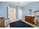 Bedroom showcasing blue walls, wood-look floors, a dresser, and a comfy chair at 2984 Ne 43Rd Rd, Ocala, FL 34470