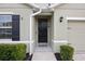 Inviting front entrance with a sleek black door, dark shutters, and tidy landscaping at 2984 Ne 43Rd Rd, Ocala, FL 34470
