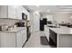 Kitchen features white cabinets, gray counters, black appliances, and tile flooring at 2984 Ne 43Rd Rd, Ocala, FL 34470