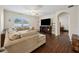Inviting living room featuring dark hardwood floors, a large sectional sofa, and a modern entertainment center at 2984 Ne 43Rd Rd, Ocala, FL 34470