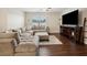 Comfortable living room showcases a plush sectional sofa, ottoman, and sleek entertainment center against dark hardwood floors at 2984 Ne 43Rd Rd, Ocala, FL 34470
