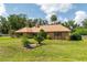 Brick home featuring mature trees, mulch beds and a well manicured lawn on a sunny day at 3555 Sw 24Th Avenue Rd, Ocala, FL 34471