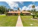Charming brick home featuring lush lawn, mature trees, and a welcoming walkway to a double door entry at 3555 Sw 24Th Avenue Rd, Ocala, FL 34471