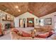 Charming living room with a stone fireplace, wood ceiling, and comfortable seating at 3555 Sw 24Th Avenue Rd, Ocala, FL 34471