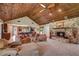 Open-concept living room with stone fireplace, wood ceiling, and connection to the eat-in kitchen at 3555 Sw 24Th Avenue Rd, Ocala, FL 34471
