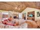 Spacious living room featuring a stone fireplace, wood ceiling, and comfortable seating at 3555 Sw 24Th Avenue Rd, Ocala, FL 34471