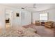 Bright main bedroom with neutral carpet, ceiling fan, sitting area, and ensuite access at 3555 Sw 24Th Avenue Rd, Ocala, FL 34471