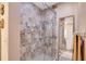 Shower featuring a unique beige and white tile design, a built-in soap holder, and a glass door at 3555 Sw 24Th Avenue Rd, Ocala, FL 34471