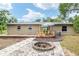 Spacious backyard featuring a brick-paved patio, firepit, and wooden deck, great for entertaining at 3640 Se 131St Ln, Belleview, FL 34420