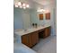 Bright bathroom featuring double vanity, a large mirror, tile flooring, and generous storage at 3650 Se 55Th Ct, Ocala, FL 34480