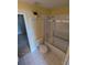 Bathroom features a toilet, shower-tub combo, decorative wall shelves and bright yellow paint at 3650 Se 55Th Ct, Ocala, FL 34480