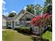 Charming home featuring a brick facade, manicured landscaping, and a beautiful blossoming tree at 3650 Se 55Th Ct, Ocala, FL 34480