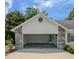 Exterior view of attached garage with brick accents, painted facade, driveway, and visible water heater at 3650 Se 55Th Ct, Ocala, FL 34480