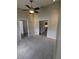 Spacious living room featuring neutral carpet, ceiling fan, and two hallways at 3650 Se 55Th Ct, Ocala, FL 34480