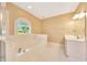 Bathroom with soaking tub, window and single sink vanity at 3769 Grove View Ln, Port Orange, FL 32129