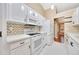 Contemporary kitchen featuring all white cabinets and appliances, complemented by a stylish backsplash at 3769 Grove View Ln, Port Orange, FL 32129