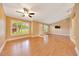 Open-concept living room featuring wood floors, large windows, and a ceiling fan at 3769 Grove View Ln, Port Orange, FL 32129