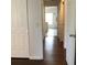 Hallway with hardwood floors, and white doors and trim leading to a brightly lit room at 3983 Sw 51St Ct, Ocala, FL 34474