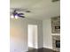 Living room with stone fireplace, neutral walls and a ceiling fan at 3983 Sw 51St Ct, Ocala, FL 34474